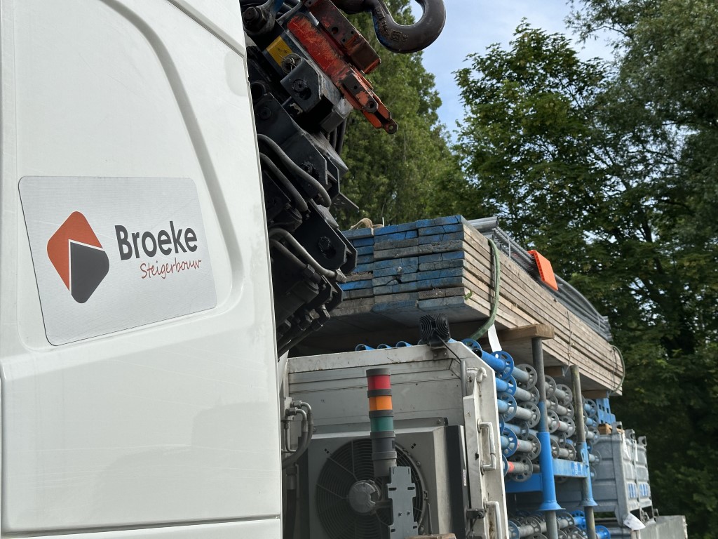 vrachtwagen broeke steigerbouw gaat lossen naar elektrische duwboot